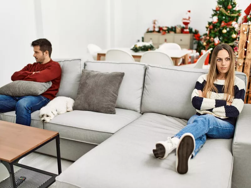 Young hispanic couple with problems sitting on the sofa in silence at home.