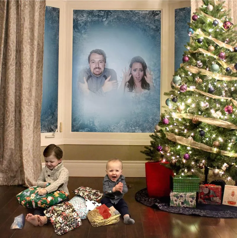 Parents in the window, kids on the floor opening presents