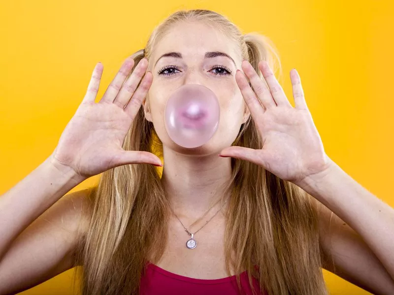 Blond girl blows up bubble gum