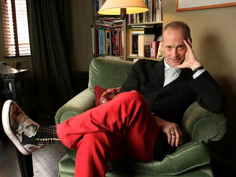 John Waters sitting at home