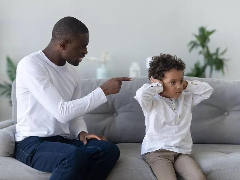 Angry single black father scolding stubborn fussy little african son