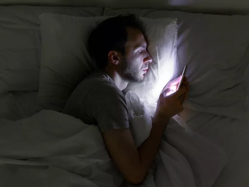 Man in bed on his smartphone