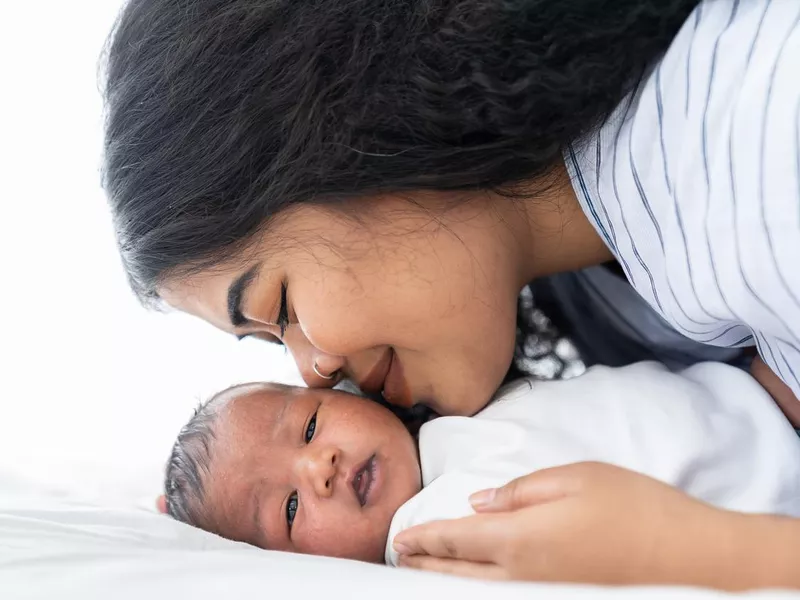 Mother kissing her newborn baby