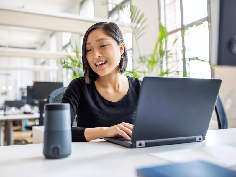 Female professional using virtual assistant at desk