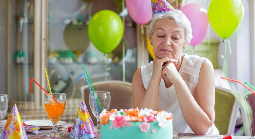 Sad elderly woman at a birthday party