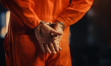 Cinematic Close Up Footage of a Handcuffed Convict at a Law and Justice Court Trial. Handcuffs on Accused Criminal in Orange Jail Jumpsuit. Law Offender Sentenced to Serve Jail Time.